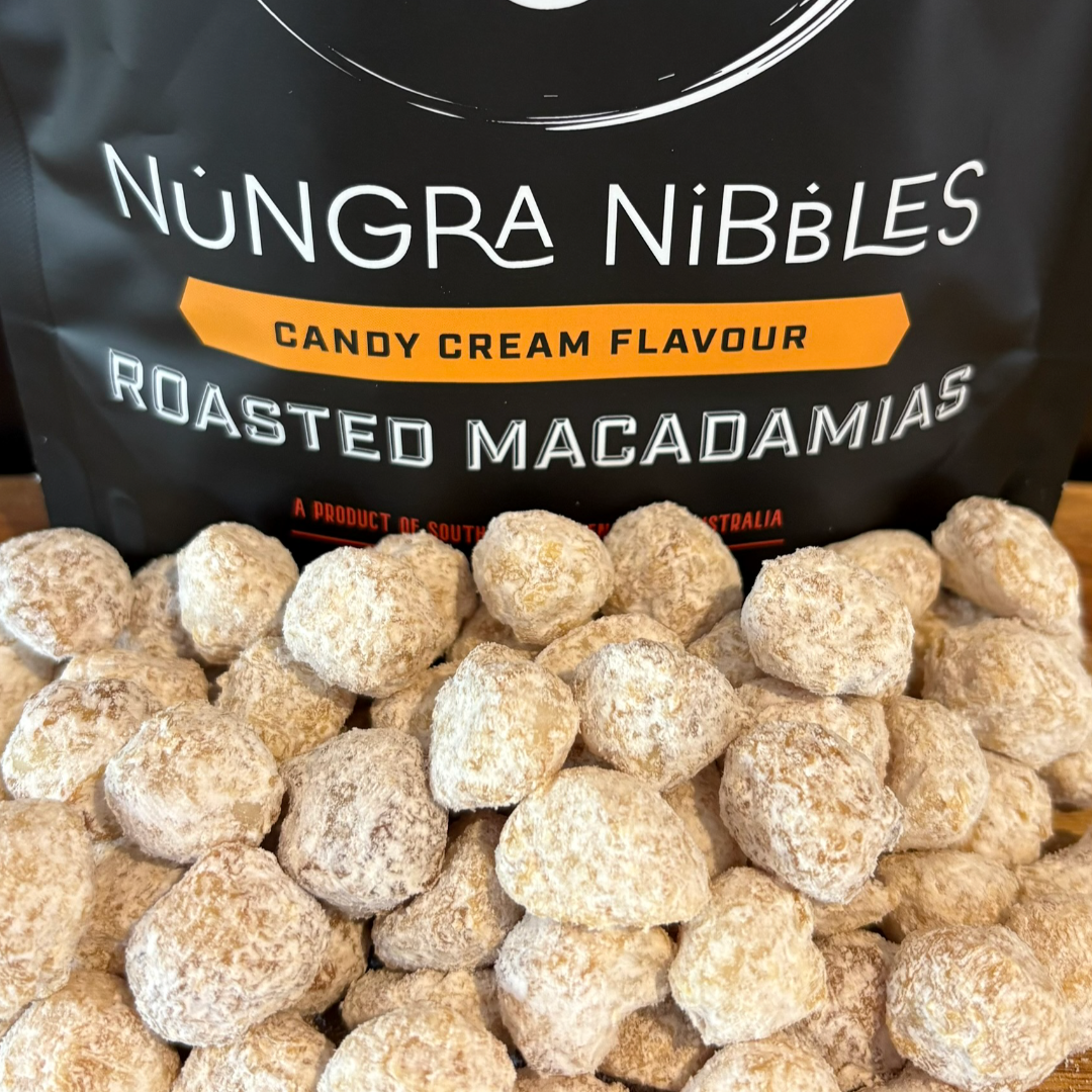 Nöngra Nibbles candy cream flavour roasted macadamias with packaging in the background.